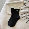 Sweet black mid-tube socks featuring white bubble ruffles and cute heart embroidery style. - One Size / Black Heart