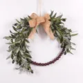 Artificial olive leaf wreath detail with green foliage, burlap bow and rustic wood beads. - 73238 Burlap Bowknot