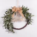 Artificial olive wreath detail showing wooden welcome sign, burlap bow and natural beads. - 73238 Burlap Bowknot + Welcome