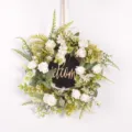 Close-up detail of artificial white rose wreath with green leaves and welcome sign decor. - White & Blackboard Welcome