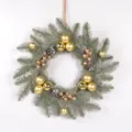 Detailed view of frosted pine needle Christmas wreath with gold ornaments, pinecones and berries. - Gold