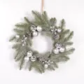 Detailed view of the Christmas wreath with frosted pine needles, silver baubles and pinecones. - Silver