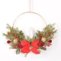 Gros plan couronne de Noël poinsettia rouge boules de velours branches de pin et bougie. - 86132+Bougie
