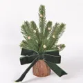 Mini Christmas tree detail view, featuring wood base, pine branches, and a green velvet bow. - Style 86119