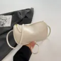 Detalle del bolso de hombro beige minimalista de cuero sintético liso con cremallera. - Blanco