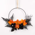 Detailansicht des Halloween-Kranzes mit schwarzen Rosen und Kürbisauge für festliche Wanddeko. - Halloween-Farbschema