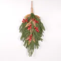Close-up detail of artificial Norfolk pine branch with red berries for Christmas wall decor. - Red