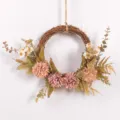 Detailed shot of an autumn artificial floral wreath with pink flowers and vine base for wall decor. - Grey Purple