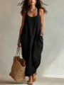 Detail shot of a black cotton linen maxi slip dress with pockets worn by model outdoors. - Black