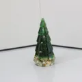 Vista detallada de la figura de árbol de navidad de resina verde con detalles de lámina dorada. - Esmalte Esmeralda