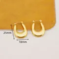Detalle en primer plano de pendientes de aro en U de acero inoxidable chapado en oro. - Pendientes Pesados en Forma de U / Dorado