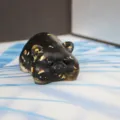 Cute black resin pig figurine with gold foil flakes, perfect for car or home decoration. - Obsidian