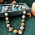 Detailopname van vintage barok statement ketting met gouden metaal, witte kralen en kristallen. - Witte Turkoois