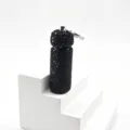 Detailed close-up view of the black rhinestone studded sub-packaging bottle keychain pendant. - Black