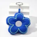 Blauer gepolsterter Blumen-Schluesselanhaenger mit hellblauer Einfassung und Metallring - Saphirblau