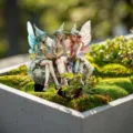 Detailed close-up of enchanting fairy figurines with wings reading books in a moss garden planter. - 30cm / Style 1