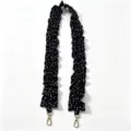 Detailed view of the black and white polka dot pleated strap with gold metal clasps. - Black With White Polka Dots / With Phone Tether Tab