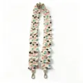 Detailed view of elastic ruffled bag strap with cute paw print pattern and gold metal clasps. - Colorful Paw Prints