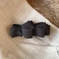 Détail de gros plan de pince à cheveux nœud en tissu gris foncé avec texture à chevron. - Brun Foncé