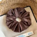 Gedetailleerd overzicht van een zachte bruine fluwelen haarelastiek in een mand. - Groot 17cm / Koffie