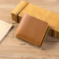 Detail view of the brown crazy horse leather short wallet, showcasing fine stitching and texture. - Tan