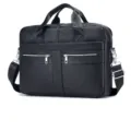 Detailed view of black genuine leather business briefcase, metal zippers, shoulder strap. - Black