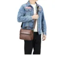 Brown leather men's messenger bag detail, showing multi-pocket design and texture. - Tan