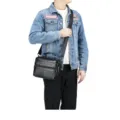 Detail view of black genuine leather men shoulder bag showing multi-pocket design. - Black