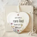 Close up detail of ceramic heart hanging ornament with watercolor floral and friendship text. - 8cm / 6