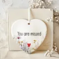 Ceramic heart hanging ornament detail showing floral design and You are missed quote with ribbon. - 8cm / 7