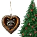 Detailed view of 2D acrylic heart-shaped tree house raccoon ornament hanging on Christmas tree. - 8x8x0.3cm / Style 4