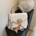 Borsa a tracolla bianca con stampa coccodrillo e chiusura a cuore di perle variante donna. - Bianco