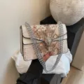 Sac à épaule élégant en motif serpent avec chaîne et fermoir tête d'animal rétro. - Blanc
