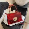 Borsa a mano in pelle coccodrillo rossa con chiusura a cuore di perle, elegante borsa donna. - Rosso