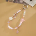 Detailed close-up of pink beaded phone charm with star and flower pendants, stylish accessory. - Cherry Blossom + Double Teardrop (Pink) / Pink