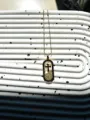 Vue détaillée d'un collier pendentif croix plaqué or en acier titane au design unique et tendance. - Croix Ovale Méandre Grec (1)