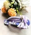 Gros plan détaillé d'une grande pince à cheveux violette décorée de perles et strass. - Style Floral Nœud en Dentelle Violette (3)