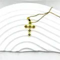 Gros plan d'un élégant pendentif croix dorée avec incrustation noire et chaîne assortie. - Style Gravé Exquis (5)