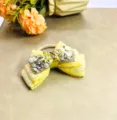 Détail d'un élastique nœud jaune étincelant avec des strass, des perles et de la dentelle. - Cravate à cheveux
