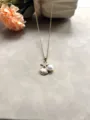 Gros plan détaillé du collier en acier titane style océan avec étoile de mer, coquillage et perle. - Blanc