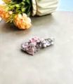 Gros plan détaillé d'une superbe barrette à nœud rose ornée de strass, perles et pendentifs. - N°8 (Nœud Rose)
