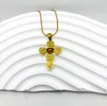 Gros plan du collier pendentif croix en acier titane doré avec des motifs de cœur. - Style Design Patchwork Coeur (4)