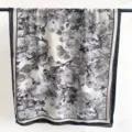 Detailed view of a black and white floral print scarf featuring elegant floral patterns. - Style 4