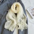Detailed shot of lightweight crinkled nylon scarf, elegant texture for autumn winter styling. - Beige