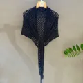 Black sequin knit shawl detail, openwork triangular scarf fabric and texture close up view. - Black