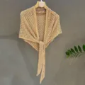 Detail shot of beige knitted sequin shawl, lightweight summer sun protection triangle scarf. - Camel