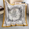 Nahaufnahme des eleganten Seiden-Quadratschals mit Paisley-Muster und auffälligem gelben Rand. - Farbe 32