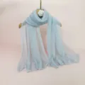 Detailed close-up of a light blue pleated metallic shawl hanging on a wooden hanger. - 70x180cm / Light Gray