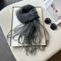 Close-up of dark grey sheer organza scarf detail showing crinkled texture and delicate fringes. - 180cm / Gray Black