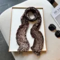 Leopard print pleated detail view showing the soft texture and crinkled design of the chic long scarf. - Dark Coffee